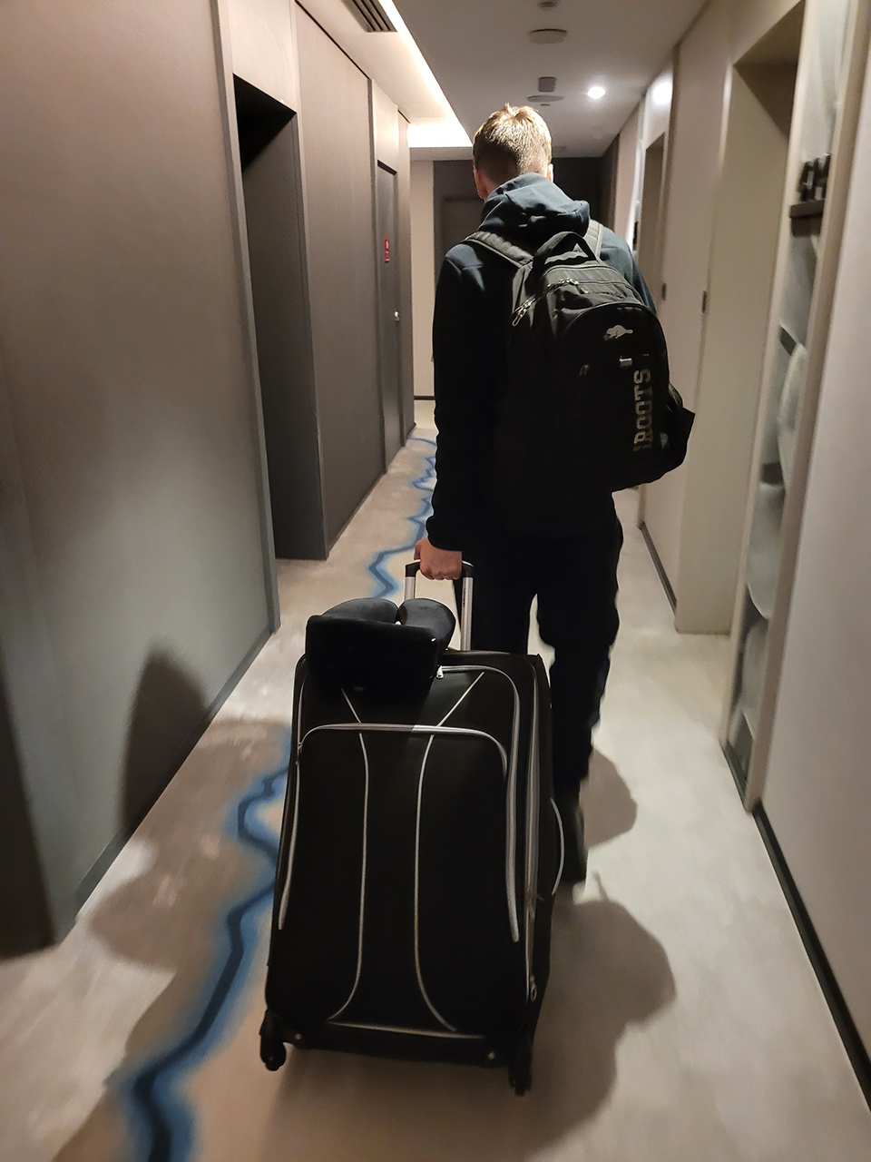 Adrian, all packed up, heading down the fourth floor corridor at the Manor Hotel by JA to begin his long journey home